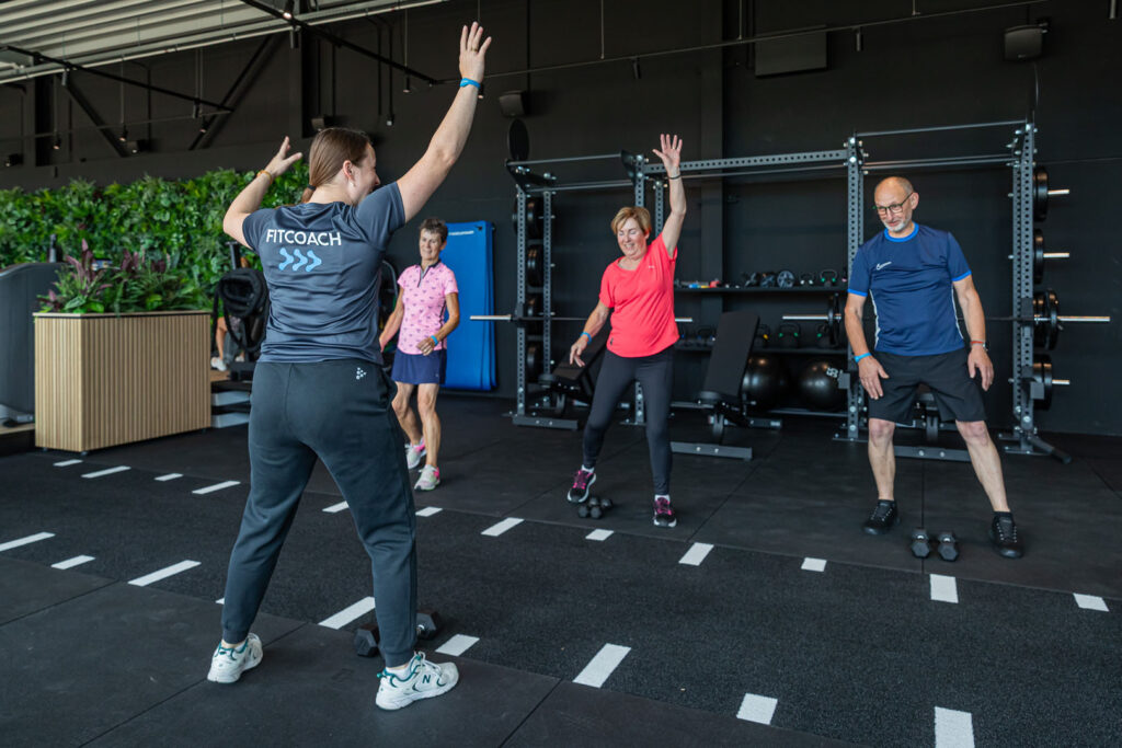 Fitcoach van Intens fit & fysio geeft een groepsles aan drie sporters